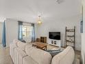 Comfortable living room with neutral tones, stylish decor, and ample natural light from the large window at 17737 Canopy Pl, Bradenton, FL 34211