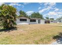 Well-maintained single-story home with a lush green lawn and mature palm tree in the front yard at 2239 Worrington St, Sarasota, FL 34231