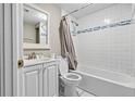 Clean bathroom with a shower-tub combo, white tile, and modern fixtures at 5004 E Seneca Ave, Tampa, FL 33617