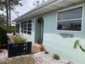Charming home featuring a light teal exterior, white rock landscaping, and bright, awning style windows at 70 Virginia Ct, Englewood, FL 34223