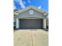 Attached garage with ample space, column accents, and convenient driveway access at 30442 Lettingwell Cir, Wesley Chapel, FL 33543