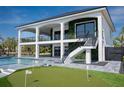 Beautiful outdoor space with a pool, putting green, and multi-level balconies on a modern home with water view at 3310 Sunset N Dr, St Petersburg, FL 33710