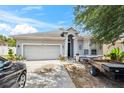 Charming single-story home with a two-car garage and well-maintained landscaping under a clear blue sky at 37110 Highland Bluff Cir, Dade City, FL 33523