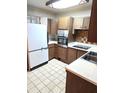 Functional kitchen featuring wooden cabinets, essential appliances, and durable tile flooring at 8641 May Cir, Tampa, FL 33614