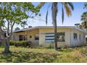 View of the front exterior of a well-maintained home with mature trees, offering shade and character to the property at 15406 2Nd E St, Madeira Beach, FL 33708