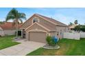 Lovely home features a two-car garage, lush lawn, and mature landscaping at 29704 Eagle Station Dr, Wesley Chapel, FL 33543