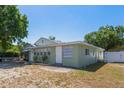 The backyard features green siding, a bright white door, windows with white trim, and minimal landscaping at 4100 46Th N Ave, St Petersburg, FL 33714