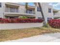 A multi-story residential building with balconies, well-maintained landscaping, and lush red shrubs at 6131 Bahia Del Mar Blvd # 139, St Petersburg, FL 33715