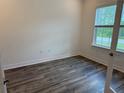 Cozy bedroom filled with natural light from the large window and modern vinyl floors at 6179 Notre Dame Ter, North Port, FL 34291