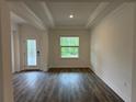 Inviting entryway with decorative glass door, tray ceiling, and sleek, dark wood flooring at 6179 Notre Dame Ter, North Port, FL 34291