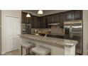 Modern kitchen with stainless steel appliances, granite countertops, and breakfast bar at 6179 Notre Dame Ter, North Port, FL 34291
