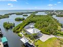 Breathtaking aerial view of waterfront home with a dock, boat lift, lush landscaping, and a serene coastal setting at 24145 Blackbeard Blvd, Punta Gorda, FL 33955