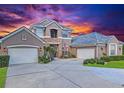 Charming home with two-car garage, a well-manicured lawn, and a sunset background at 3008 Sutton Woods Dr, Plant City, FL 33566