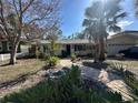Beautiful home exterior showcasing lush landscaping, brick pathway, and mature trees in the front yard at 560 7Th S St, Safety Harbor, FL 34695