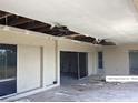 Damaged patio with missing ceiling tiles, a fan, sliding glass doors, and an exit door at 3360 Peace River Dr, Punta Gorda, FL 33983