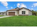Beautiful single-story home featuring a well-manicured lawn and a two-car garage with brown doors at 5163 Arley Ct, North Port, FL 34288