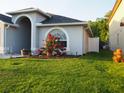 Charming single Gathering home featuring a well-manicured lawn, gray siding, and a lovely garden at 30643 Tremont Dr, Wesley Chapel, FL 33543