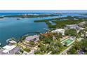 Aerial view of waterfront estate with beautiful landscaping, private dock, and access to open water at 112 Osprey Point Dr, Osprey, FL 34229