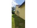 The side yard features a well-maintained lawn with mature trees and minimal landscaping with a small, utilitarian structure at 7418 Riverbank Dr, New Port Richey, FL 34655