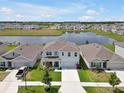 A scenic aerial view of home nestled in a neighborhood with serene pond and well-maintained lawns at 5289 Fiddle Fig Ave, Wimauma, FL 33598