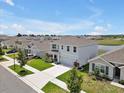 Inviting aerial shot of a home near a pond in a lovely community with manicured lawns and mature trees at 5289 Fiddle Fig Ave, Wimauma, FL 33598