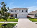 Attractive two-story home with well-manicured lawn and colorful landscaping enhances curb appeal at 5289 Fiddle Fig Ave, Wimauma, FL 33598