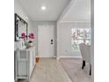 Inviting foyer featuring tile flooring, a stylish mirror, and a glimpse into the adjacent dining area at 5289 Fiddle Fig Ave, Wimauma, FL 33598