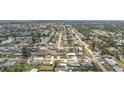 Wide aerial view of a tranquil residential community with mature trees and a scenic lake nearby at 1790 Pomelo Dr, Venice, FL 34293