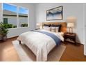 Bright bedroom featuring a wood bed frame, white bedding, blue accents, and modern nightstands with lamps at 5154 51St W Ln, Bradenton, FL 34210