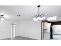 Open dining area featuring modern light fixtures, freshly painted walls, and updated floors at 7490 Locust Ne St, St Petersburg, FL 33702