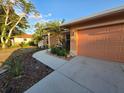 Well-maintained home exterior with a tidy lawn, attractive landscaping, and a driveway leading to an attached garage at 22227 Elmira Blvd, Port Charlotte, FL 33952