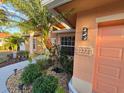 Close-up of the exterior, showcasing lush greenery, a palm tree, and the house number at 22227 Elmira Blvd, Port Charlotte, FL 33952