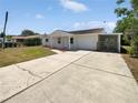 Charming single-story home features a quaint front porch, attached garage, and large driveway at 38832 Henry Dr, Zephyrhills, FL 33542