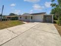 Charming single-story home features a quaint front porch, attached garage, and large driveway at 38832 Henry Dr, Zephyrhills, FL 33542