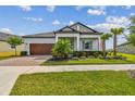 Beautiful home showcasing a well-manicured lawn, mature trees, and colorful flower beds enhancing the curb appeal at 31840 Magna Gulf Loop, San Antonio, FL 33576