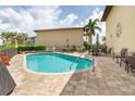 Community pool with brick patio and outdoor seating at 3221 White Ibis Ct # C1, Punta Gorda, FL 33950