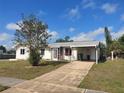 Inviting single-level residence with a carport, a well-kept lawn, and mature shade tree at 4299 Bullard St, North Port, FL 34287