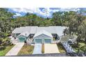 Street view of the townhomes featuring attached garages and well-maintained landscaping at 12519 Knollbrook Ln, Hudson, FL 34669