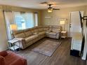 Comfortable living room with hardwood floors, a large sectional sofa, and natural light from the windows at 13122 Cumberland Dr, Largo, FL 33773