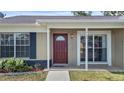 Inviting front porch with a red front door, large window and meticulously maintained landscaping at 1904 Crown Park Dr, Valrico, FL 33594