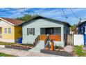 Charming single-story home featuring a cozy front porch with a wooden railing and fresh landscaping at 2904 Sanchez St, Tampa, FL 33605