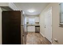 Efficient kitchen featuring stainless steel appliances, white cabinets, granite counters, and wood-look flooring at 4812 N 37Th St, Tampa, FL 33610