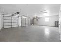 Spacious three-car garage featuring a concrete floor, ample lighting, and garage door openers at 709 Tuscanny St, Brandon, FL 33511