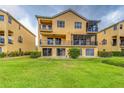Back of home featuring balconies, a screened lanai, a patio, and a well-maintained lawn at 1408 3Rd Street E Cir, Palmetto, FL 34221
