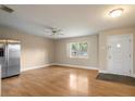 Bright living room featuring hardwood floors, ceiling fan, stainless steel refrigerator and front entrance at 408 Eunice Dr, Plant City, FL 33563