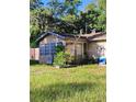 Cozy home with stone siding and a charming sunroom, surrounded by lush greenery at 820 Bayou Ave, Tarpon Springs, FL 34689