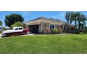 Well-maintained single-story home featuring arched windows, side entry garage and a lush green lawn at 2668 Jablo Cir, North Port, FL 34288