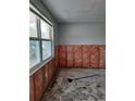 Room with a large window and exposed wall framing, ready for renovation and personalized touches at 7240 Donna Dr, New Port Richey, FL 34652