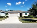 Well-maintained single-story home with manicured landscaping, spacious driveway, and attached two-car garage at 5144 Flowing Oar Rd, Wimauma, FL 33598