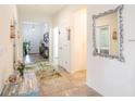 Bright and inviting hallway with tile flooring, leading to various rooms and the front door at 5144 Flowing Oar Rd, Wimauma, FL 33598